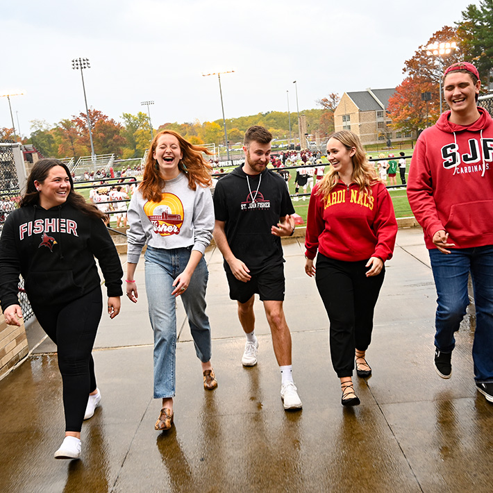 Fisher students walk on campus together with smiles.